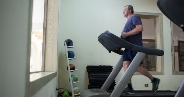 Timelapse van een senior man trainen op loopband — Stockvideo