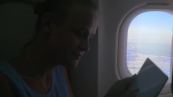 Женщина с табличкой у окна самолета — стоковое видео