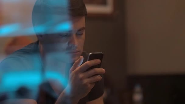 Чоловік використовує смартфон у кафе — стокове відео
