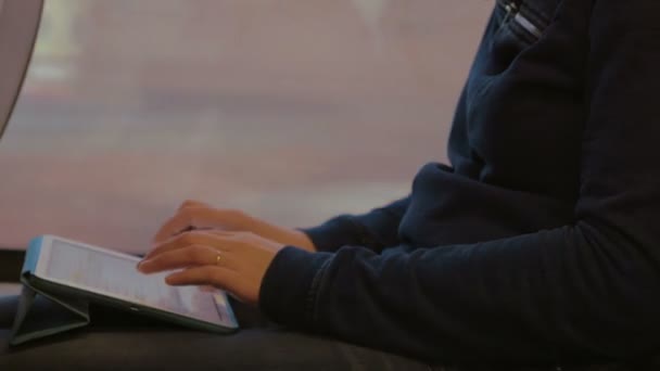 Женщина пишет на планшетном компьютере во время поездки — стоковое видео