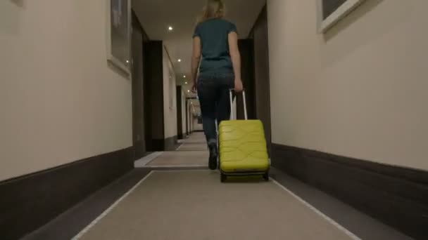 Kvinnan promenader längs Hotel passagen med Trolley väska — Stockvideo