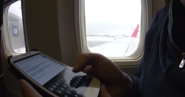 Internet surfing on cell phone before flight — Stock Video