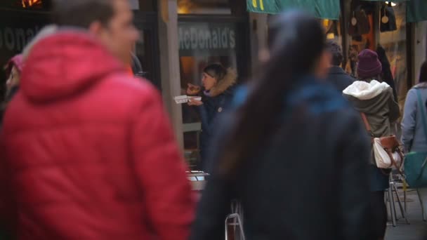 Mujer comiendo comida rápida por la entrada al restaurante — Vídeo de stock