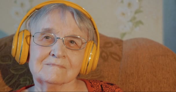 Mujer mayor en auriculares escuchando música — Vídeo de stock