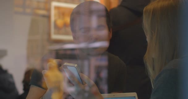 Vrouw en man hebben een discussie in het restaurant met smartphone — Stockvideo