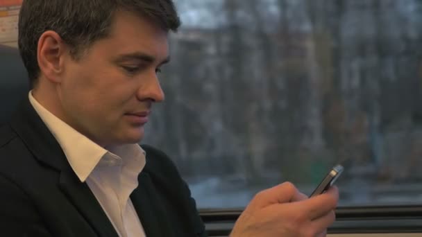 Uomo d'affari Utilizzando Smartphone in treno — Video Stock