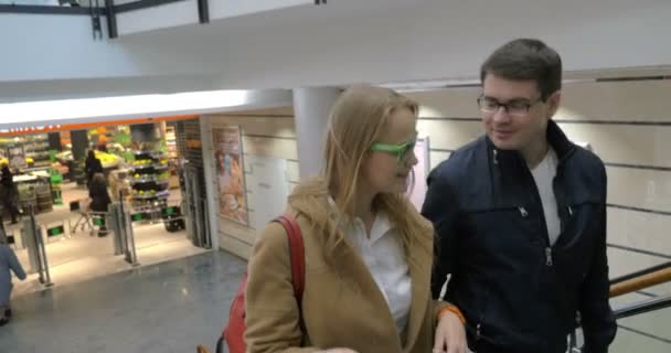 Hombre y mujer caminando arriba en el centro comercial — Vídeos de Stock