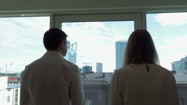 Zwei Geschäftsleute gehen zum Fenster im Büro — Stockvideo