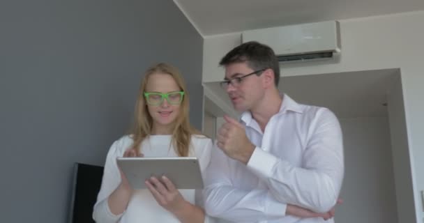 Büroangestellte diskutieren über Geschäfte und die Nutzung von Tablet-Computern — Stockvideo