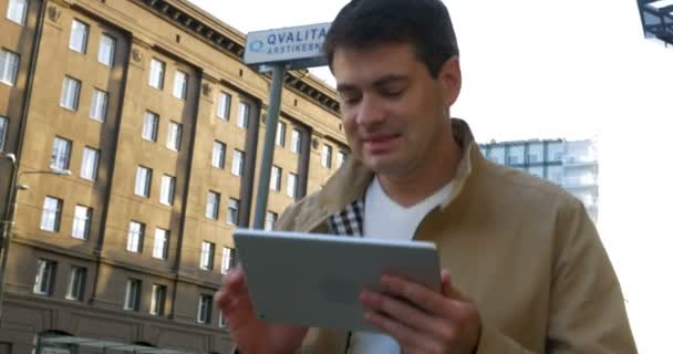 Hombre usando tableta de computadora en el camino en la ciudad — Vídeo de stock