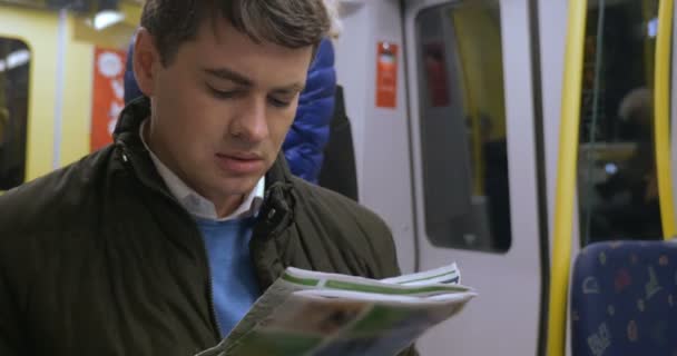 Commuter spending time with newspaper in underground train — Stock Video