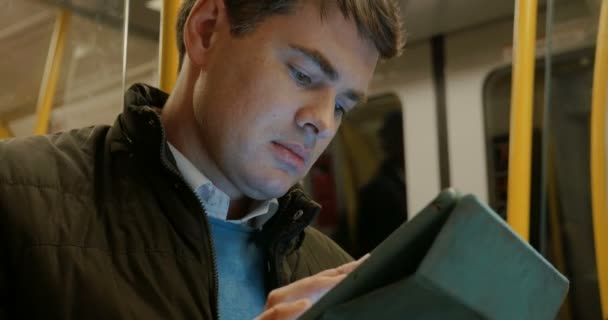 Человек, использующий планшетный компьютер в метро — стоковое видео