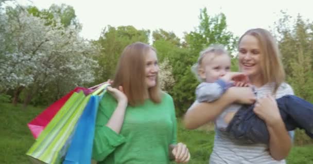 Deux femmes avec un enfant marchant dans un parc vert — Video