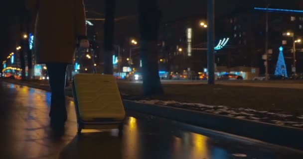 市内の通り沿いのトロリー バッグと一緒に歩いている女性 — ストック動画