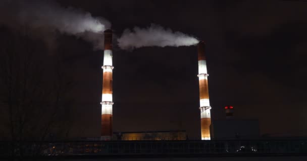 Pijpen van de fabriek in de stad bij nacht — Stockvideo
