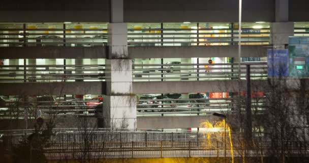 Timelapse of traffic near parking deck at night — Stock Video