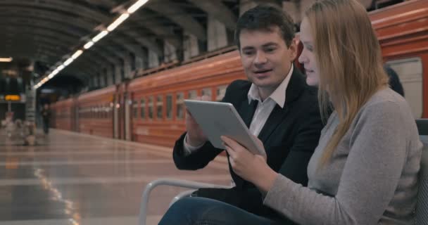 Молодые люди используют планшетный компьютер в метро — стоковое видео
