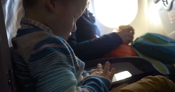 Criança no avião usando smartphone — Vídeo de Stock