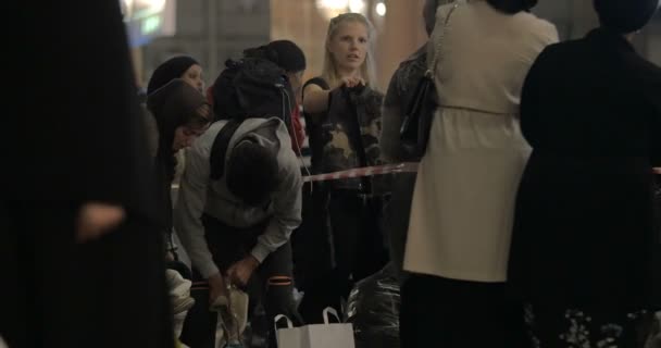 Female Aid Worker Distributing Clothes at Charity Collecting Point in Copenhagen Railroad Station — Stock Video