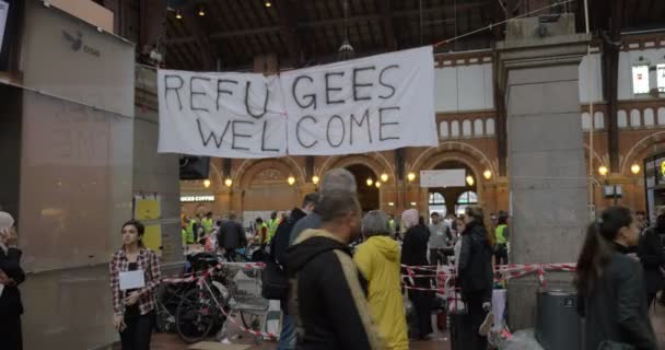 Baner Uchodźcy Witamy wisi przez charytatywny punkt zbierania w Kopenhadze PKP — Wideo stockowe