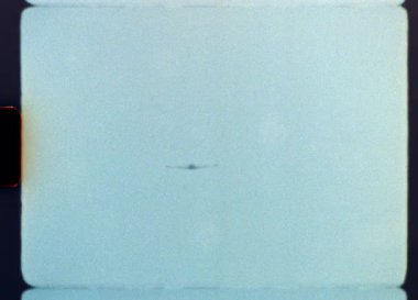 Süper 8 kameranın otantik arşiv görüntüleri, klasik film tahılları, ışık sızıntıları ve klasik klasik dönemin yuvarlak köşeleriyle temiz bir gökyüzünde uçan eski bir pervane uçağını gösteriyor.