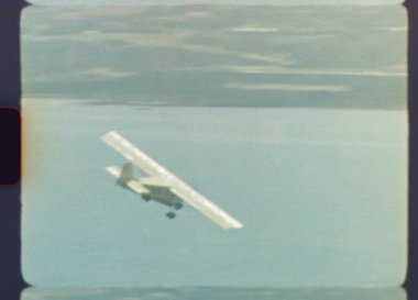 1970 'lerde sisli bir sahil şehrinde uçan ve dönen hafif bir uçağın otantik arşiv görüntüleri, karakteristik tahıllar, ışık sızıntıları ve yuvarlak köşelerle Süper 8 filminde çekildi.