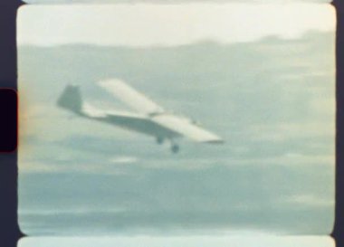 Orijinal, Otantik 8mm film kaydı. Nüfusun yoğun olduğu bir bölgeye inmek için zarif bir şekilde inen küçük bir uçağın gerçek ışık sızıntıları ve film tahıllarıyla nostaljik bir yolculuk görüntüsü.