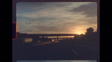 Günbatımı ışığı otoban üst geçidinde özgün analog film tahılları ve yumuşak odaklı klasik 8 mm 'lik filmle çekilen nostaljik bir sürüş sırasında parlıyor.