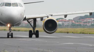 Görünür türbin dönüşüyle pistte ağır çekimde hareket eden ticari jetin yakın görünümü