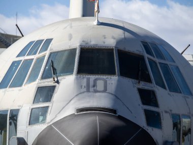 Uçuş güvertesinin yakın çekimleri ve açık havada anıt olarak tutulan eski bir askeri nakliye uçağının gövdesi.