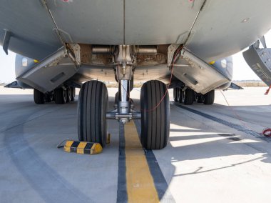 Görünür tekerlek tıkanması olan beton pistin ortasında çift tekerli ön iniş takımları.