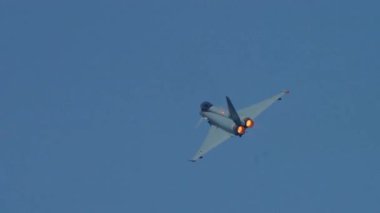 Yüksek hızlı dönüş sırasında parlayan art yakıcılarla savaş uçağı bankacılığı