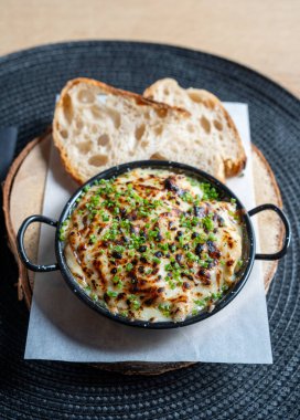 Üzeri taze soğanla kaplı kremalı ızgara ve yanında da kır ekmeği..