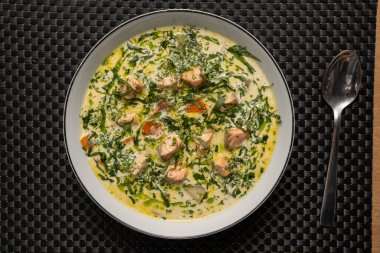 Süslü somon çorbası. Taze otlarla süslenmiş. Beyaz bir kasede..