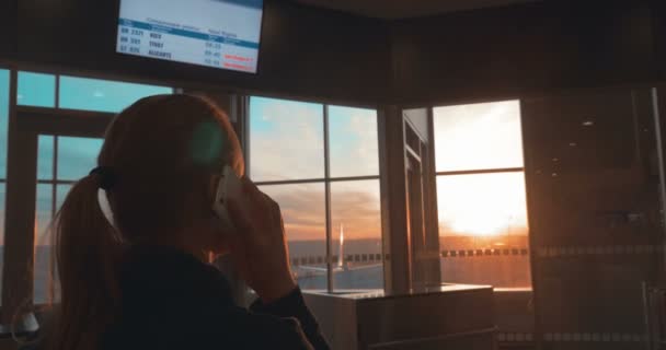 Жінка має телефонну розмову в аеропорту — стокове відео