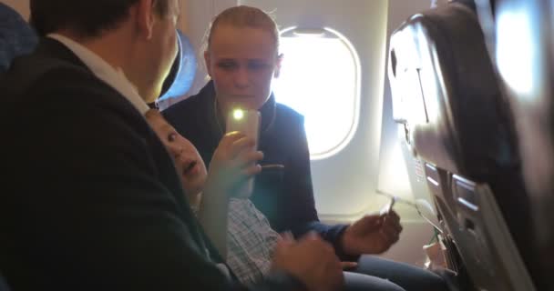 Divertissement pendant le voyage en famille en avion — Video