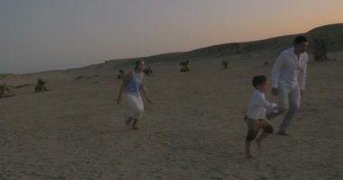 Anne ve oğlu kumsalda futbol oynarken