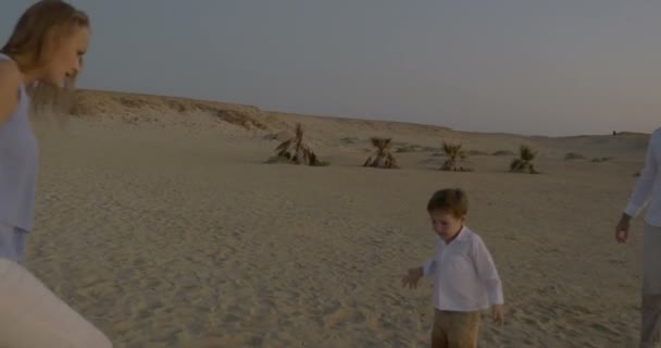 Actieve spel met kind op het strand bij zonsondergang — Stockvideo