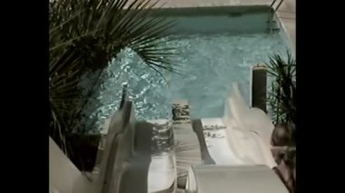 Bir su kaydırağının başlangıç noktasından açık havuz ve palmiye ağaçlarının yukarıdan görünüşü