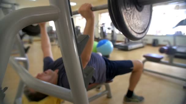 Haciendo press de banco en el gimnasio — Vídeo de stock