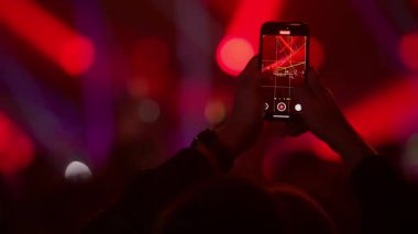 Eller akıllı telefon kayıt konser yoğun sahne aydınlatma ve dinamik elektronik müzik atmosferi ile