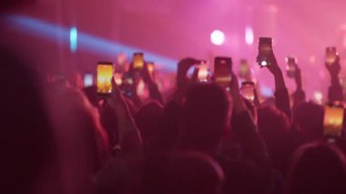 Geniş izleyiciler ellerinde akıllı telefonlar ve canlı konserleri renkli dinamik ışıklandırma ve güçlü müzik enerjisi altında yakalıyorlar.
