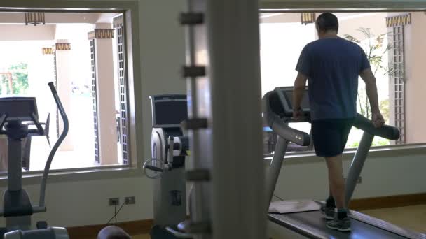 Trainieren auf dem Laufband in modernem Fitnessstudio — Stockvideo