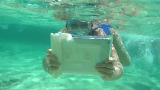 Woman diving with pad to make a good underwater shot — Stock video