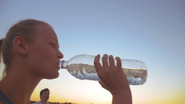 Мужчина и женщина пьют воду на открытом воздухе — стоковое видео