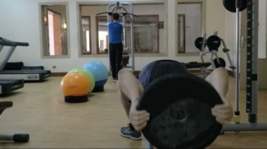İki adam spor salonunda spor donanımları kullanarak eğitim