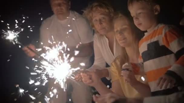 Moeder en zoon met wonderkaarsen nachts — Stockvideo