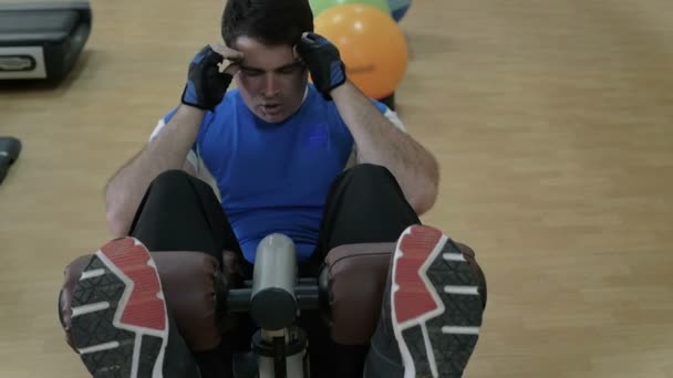 Hombre haciendo sentadas en el banco abdominal — Vídeos de Stock