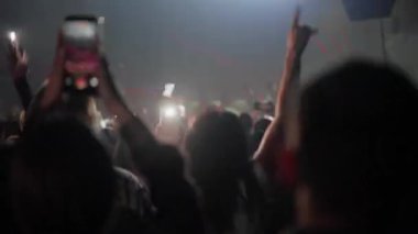 Seyirciler, parlak sahne ışıkları ve dinamik lazer ışınları olan akıllı telefonları kullanarak bir konser kaydediyor.