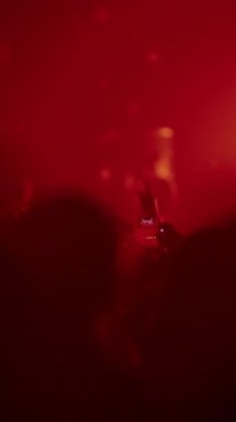 Sahne altında akıllı telefonları kullanarak konser seyircilerinin karanlık siluetleri
